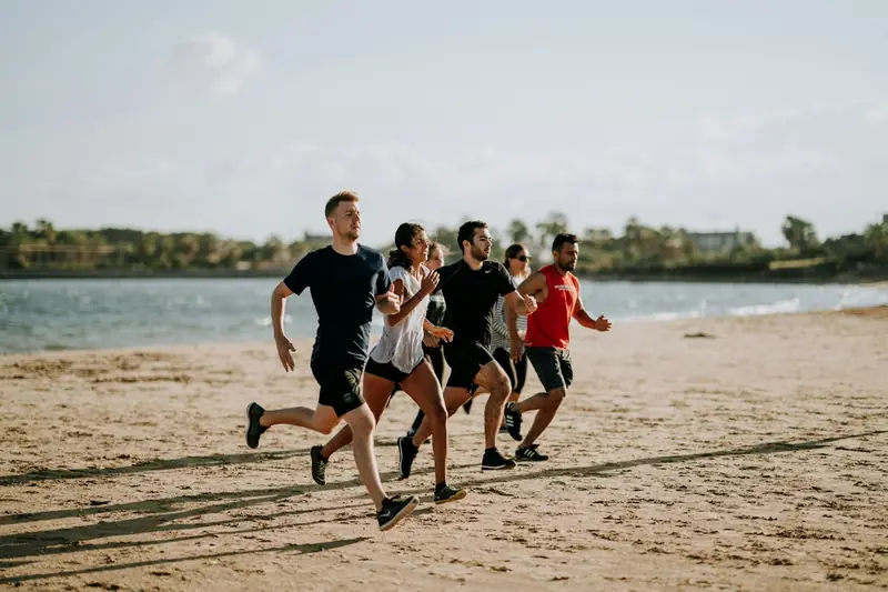 A group running together along a beach.
